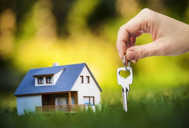 hand holding key against house background