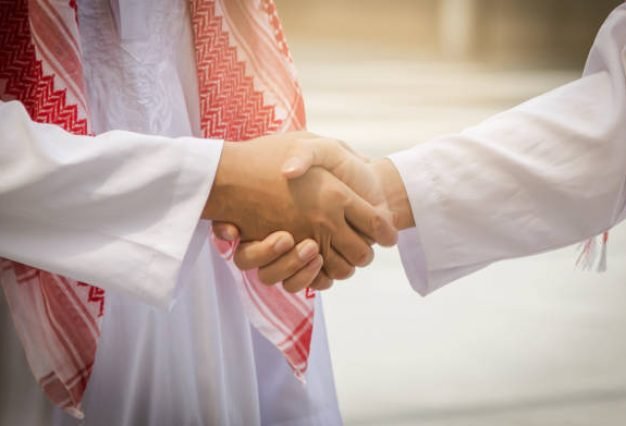 Arab and businessman are shaking hand on cityscape background, Business Successful concept
